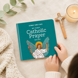 Childs hands holding the Catholic prayer board book beside a crucifix and candle