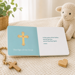 Open board book showing the Sign of the Cross page with a gold cross