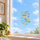Hail Mary prayer window cling on a bright window with blue sky and clouds behind it.